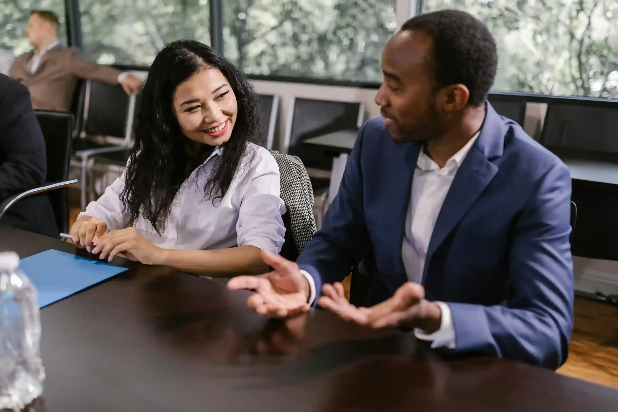 Two professionals engaged in a discussion during a business meeting