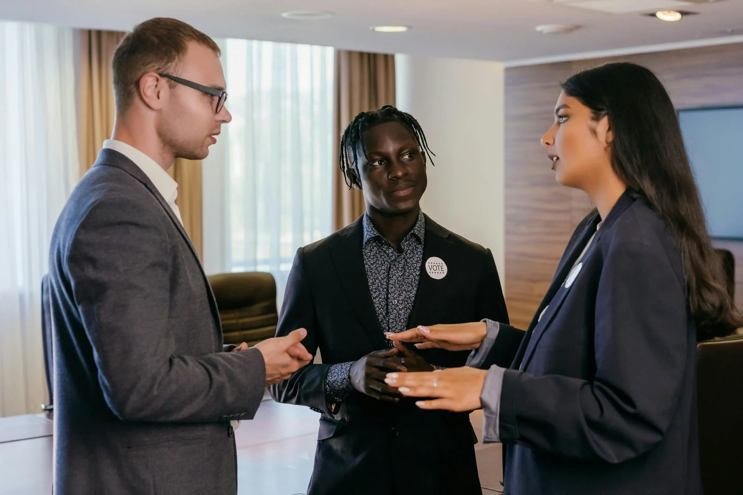 Three professionals engaged in a discussion in a modern office setting